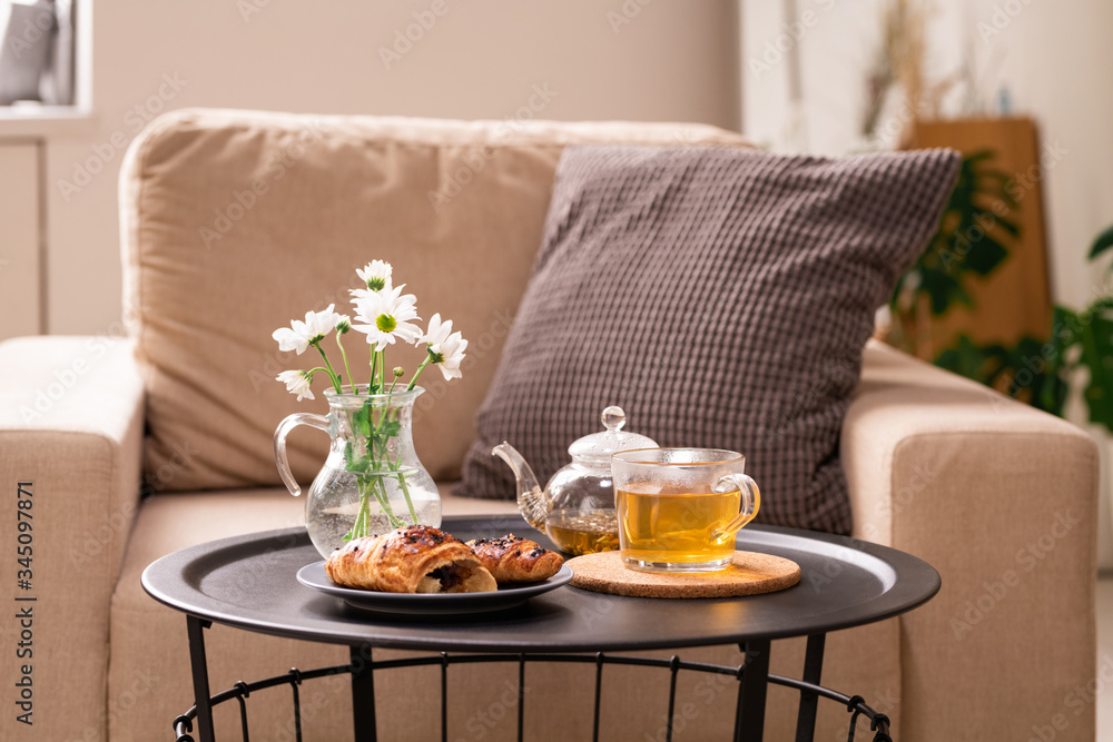 Bunch of white flowers in jug with water, snack on plate and green herbal tea Bunch of white flowers in jug with water, snack on plate and green herbal tea