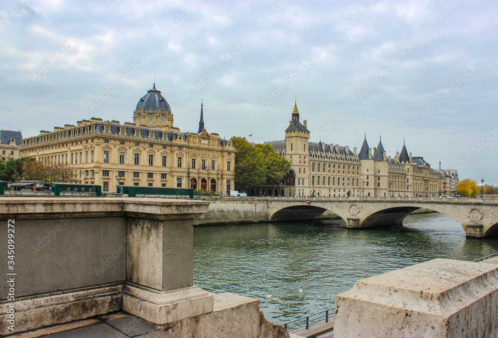 Urban landscape and architecture of the city of Paris. Beautiful houses with dark roofs and spires, a stone bridge over the river, a balustrade. Autumn.France.