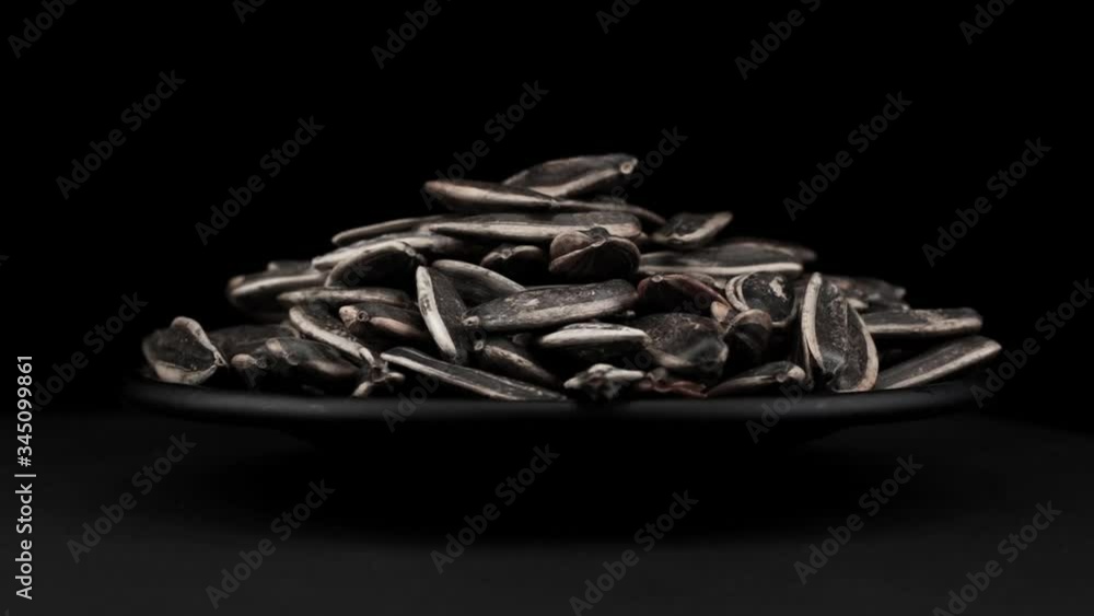 Sunflower seeds of spin around themselves on a black background and ground Sunflower seeds of spin around themselves on a black background and ground