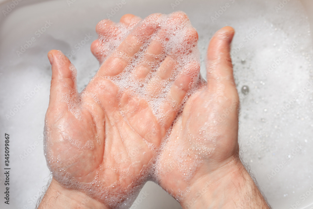 a man washes his hands over water with foam a man washes his hands over water with foam