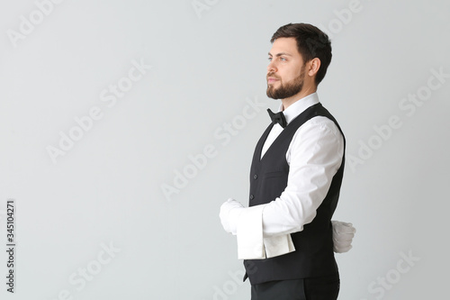 Handsome male waiter on gre...
