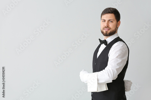 Handsome male waiter on gre...