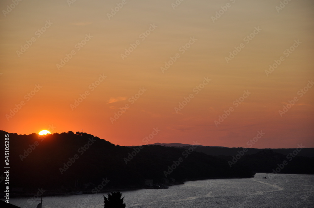 Red sunset over the mountains and Adriatic Sea. Mediterranean island Losinj sunset. Red sunset over the mountains and Adriatic Sea. Mediterranean island Losinj sunset.