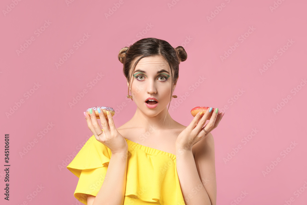 Surprised young woman with beautiful manicure and donuts on color background Surprised young woman with beautiful manicure and donuts on color background