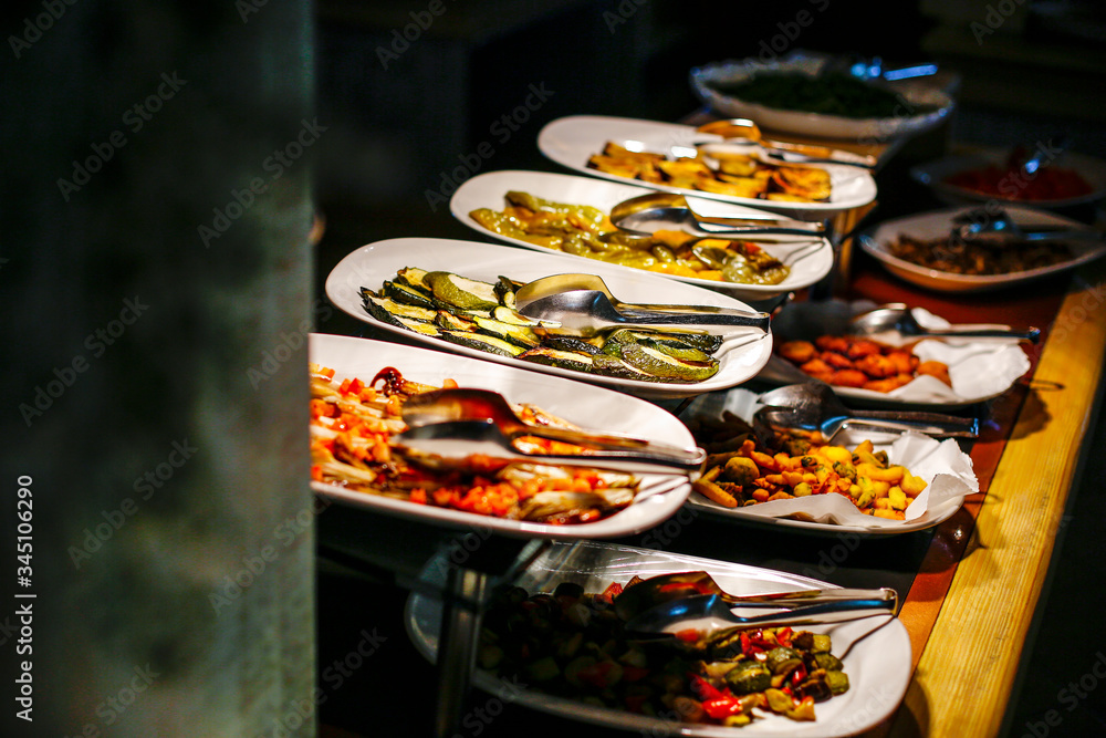 Self- service con piatti e presine per poter scegli la quantità di cibo desiderata in una ristorante
