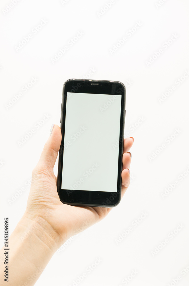 Woman's hand holds a black phone with white screen on white background. Woman's hand holds a black phone with white screen on white background.