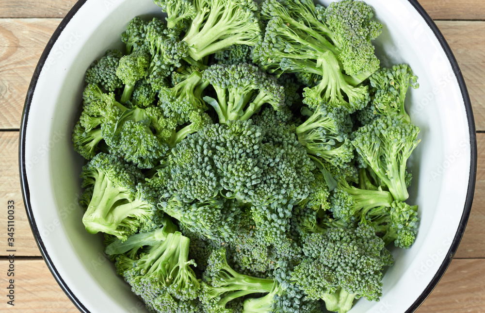 Broccoli green plant harvest in a bowl on wood, from above overhead view, flat lay, closeup, protein vegetables and organic homegrown vegan food concept Broccoli green plant harvest in a bowl on wood, from above overhead view, flat lay, closeup, protein vegetables and organic homegrown vegan food concept