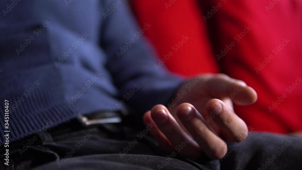 A man drinks from a Christmas decorated cup and sits on a couch in a living room - closeup