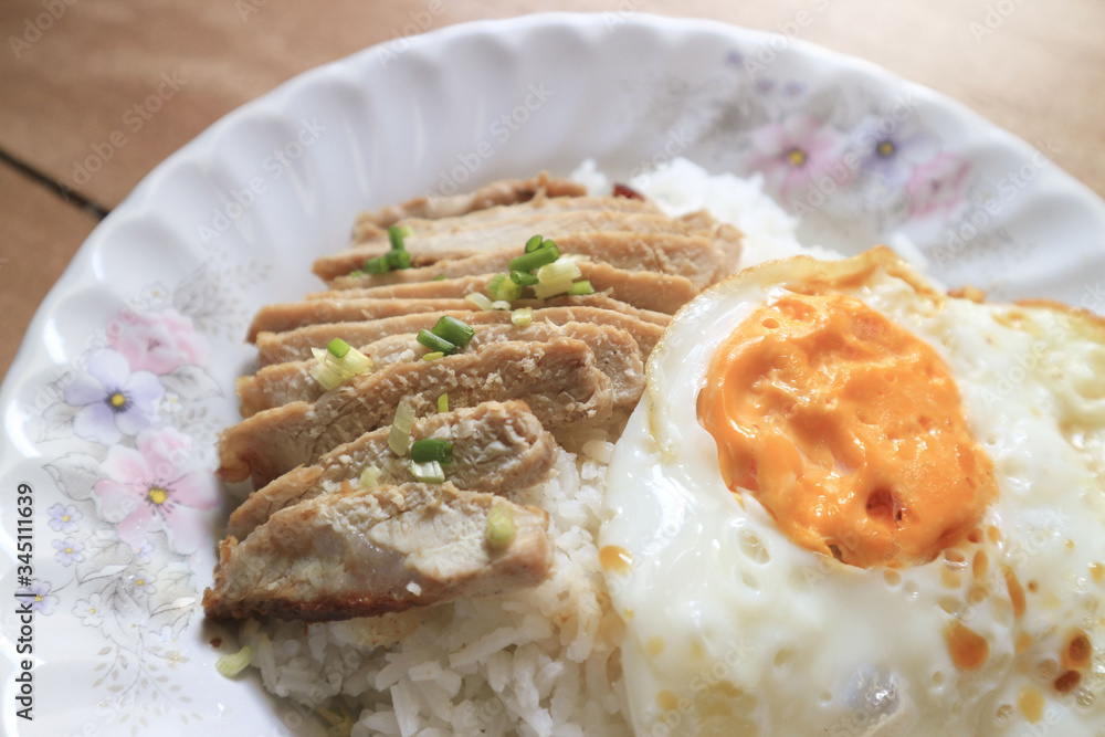 Fried egg with grilled beef and rice on a plate