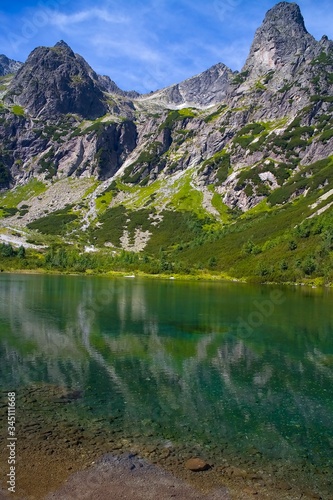 Fototapeta Naklejka Na Ścianę i Meble -  Green lake surrounded by Tatra peaks.