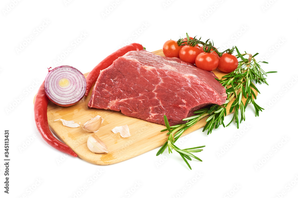 A large piece of fresh meat tenderloin, with rosemary, red pepper, garlic and cherry tomatoes lies on the cutting board on a white background. A fresh piece of knuckle. A large piece of fresh meat tenderloin, with rosemary, red pepper, garlic and cherry tomatoes lies on the cutting board on a white background. A fresh piece of knuckle.