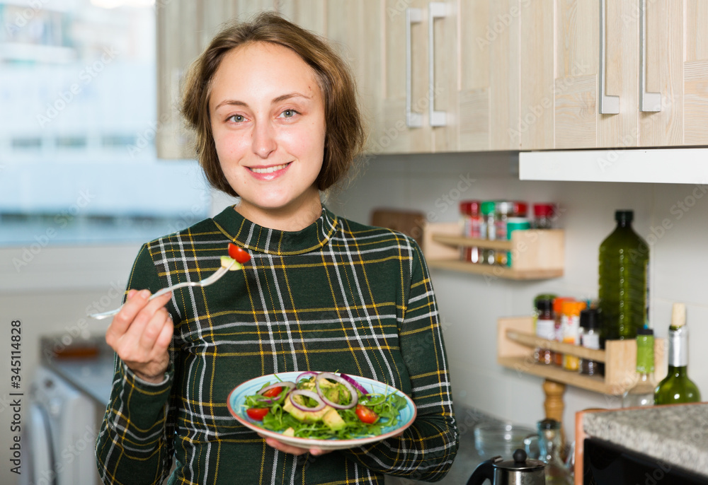 Woman standing with salad at kitchen