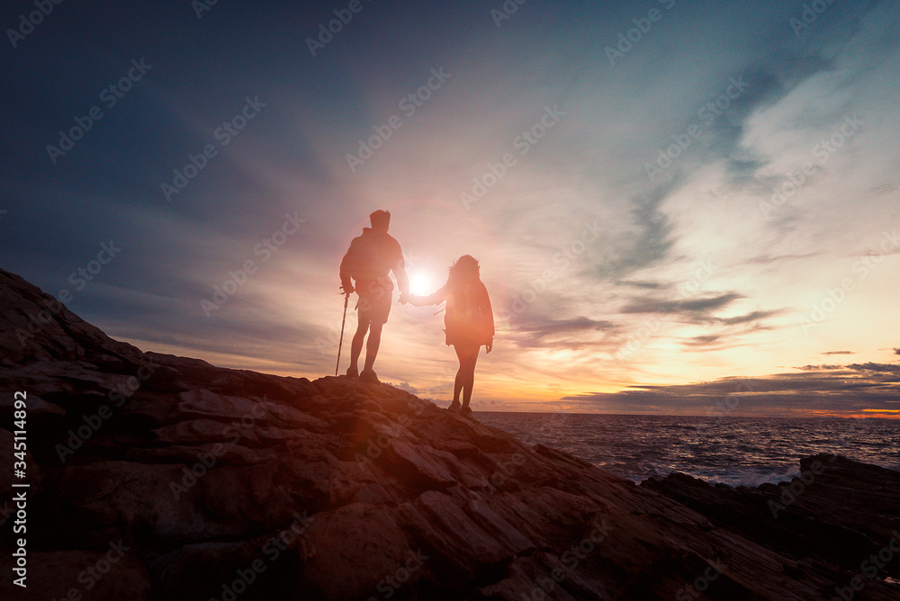 Young asian couple climbing up on the mountain,hiking and team work and love concept, Successful team, Team with success standing on the top of mountain, Team of climbers man and woman hiker