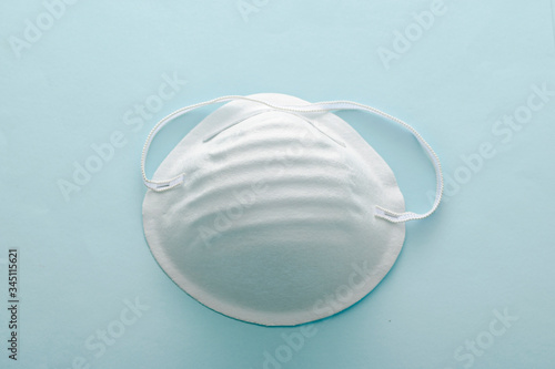 Single surgical face mask on a grey background