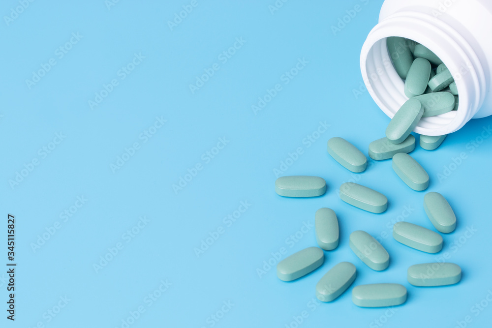 Medical pills on blue background with copy space.