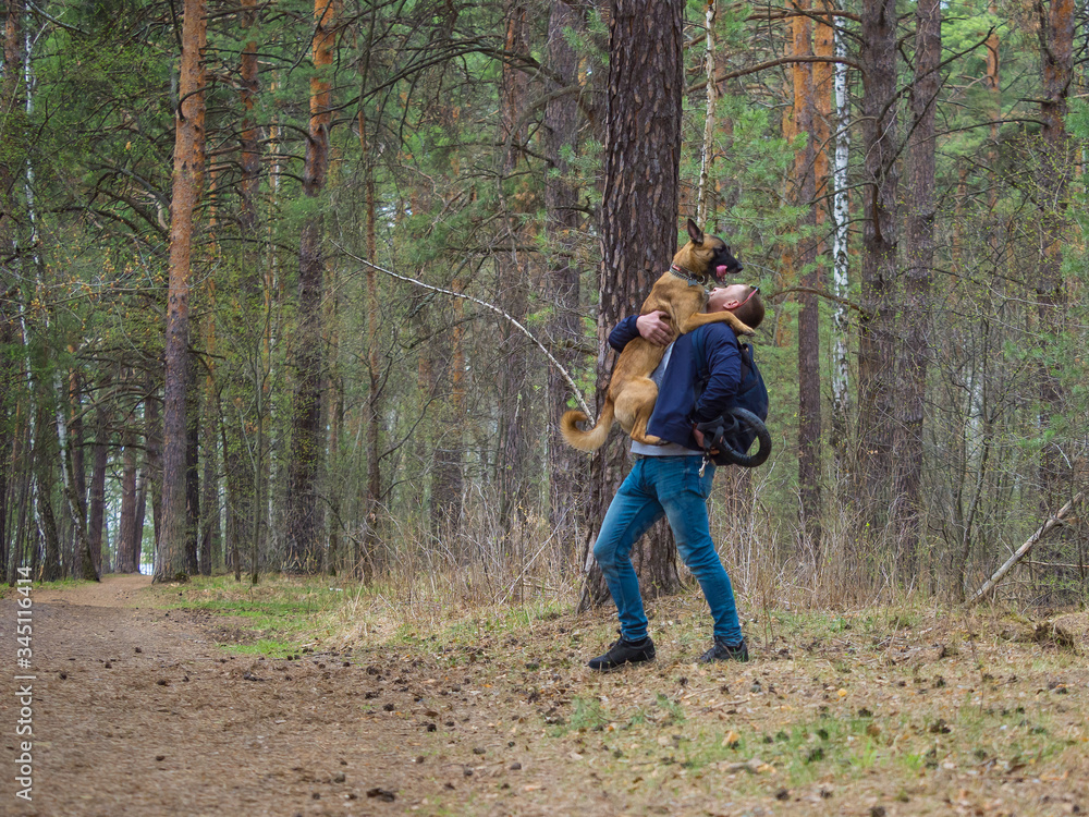 A man is playing in the forest with his dog. Love pets and friendship concept.