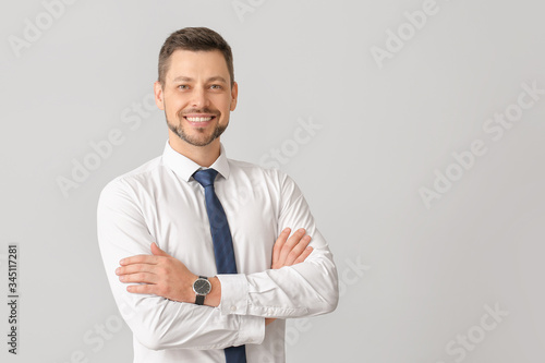 Portrait of handsome businessman on light background © Pixel-Shot