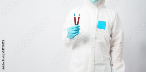 Male model with PPE suite and Hand with glove is holding blood test tube on white background.