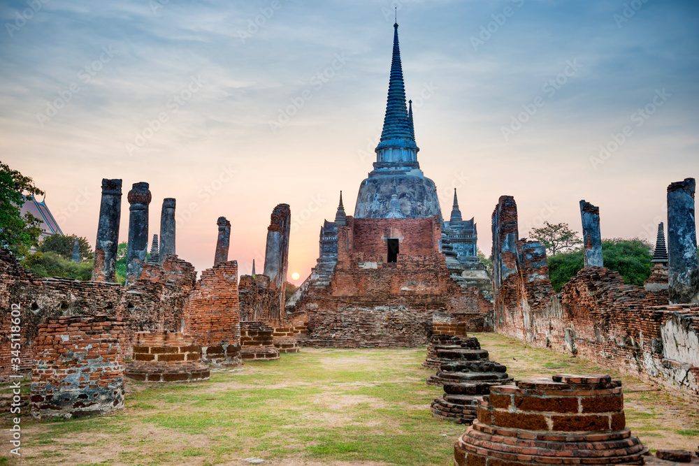 Obraz premium Night in brick ruins of ancient buddhist temple Wat Phra Si Sanphet at sunset. Architecture of Ayutthaya historical park, Thailand
