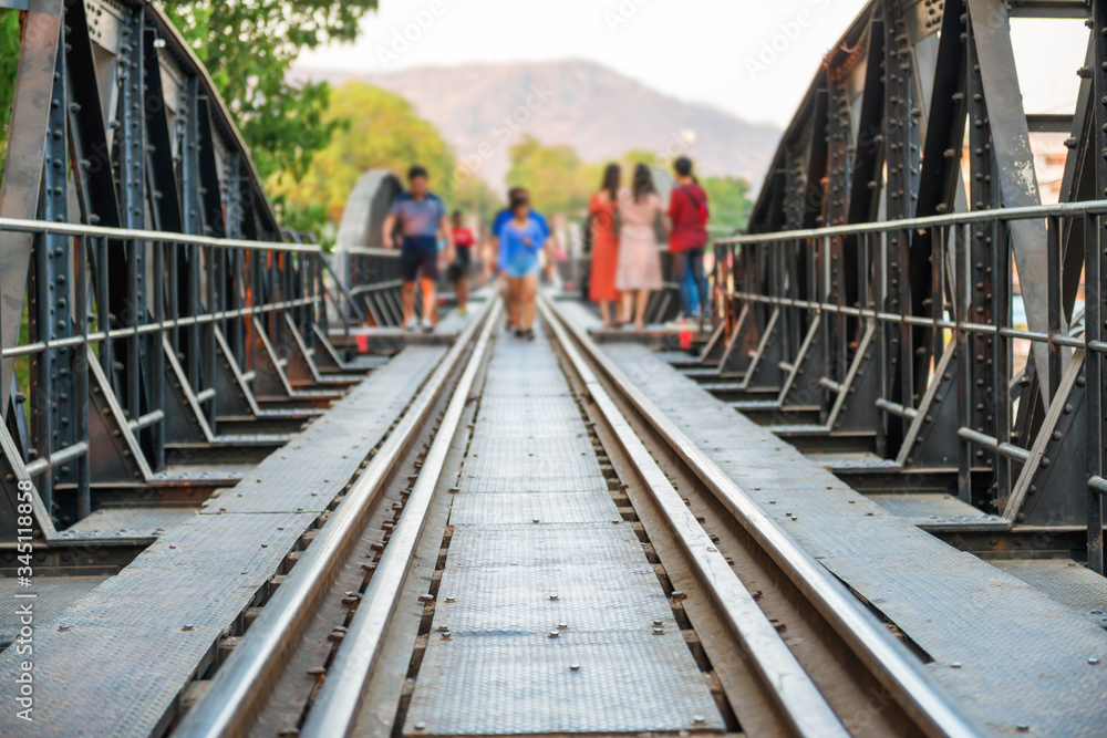 Crowd of people walking by rail track of old railroad bridge on river Kwai. Kanchanaburi, Thailand Crowd of people walking by rail track of old railroad bridge on river Kwai. Kanchanaburi, Thailand