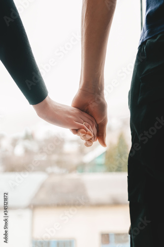 Closeup of loving couple holding hands while walking in the town