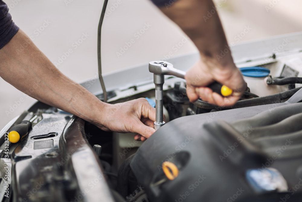 Man master repairs under the hood of the car Man master repairs under the hood of the car
