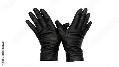 Hands wearing black leather gloves thumbs crossing, fingers pressed together, palms down. Female hand isolated, no skin. Hand casting a spell gesture