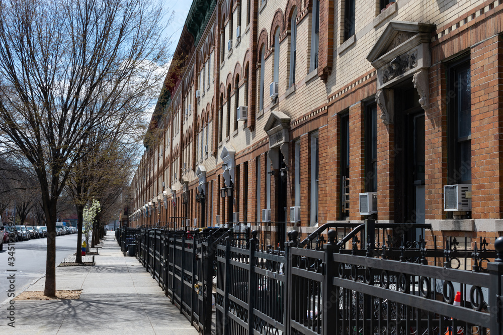 Fototapeta premium Row of Similar Apartment Buildings along an Empty Sidewalk in Astoria Queens New York