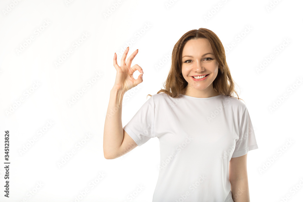 beautiful young woman in white t-shirt on a white background with hand gesture beautiful young woman in white t-shirt on a white background with hand gesture