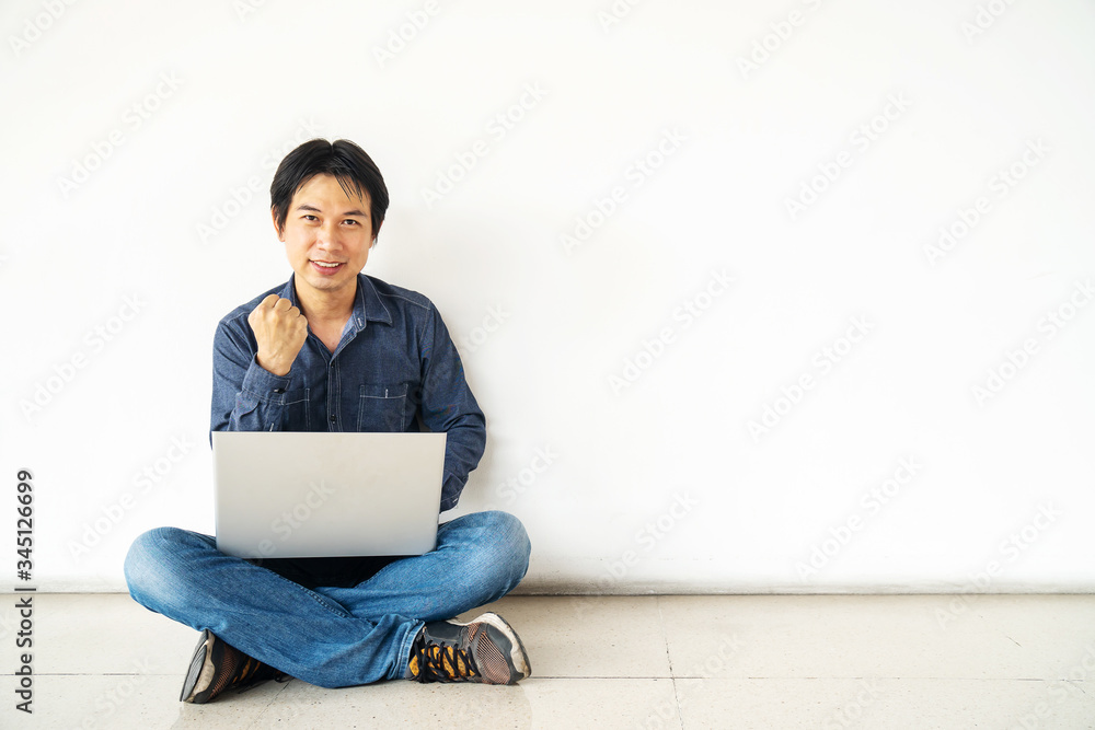 Young man asian sitting on the floor with using computer laptop happy excited with big smile posing isolated over white wall . Young man asian sitting on the floor with using computer laptop happy excited with big smile posing isolated over white wall .