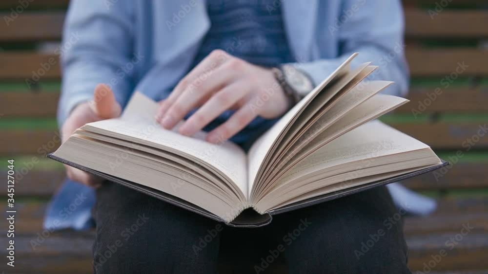 A man is studying textbooks, sitting quietly in a park on a bench A man is studying textbooks, sitting quietly in a park on a bench