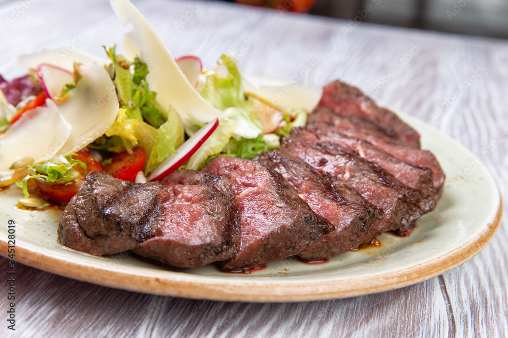 salad and sliced steak in a plate.