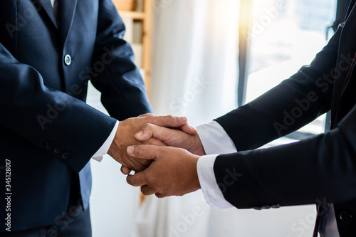 successful negotiate and handshake concept, two businessman shake hand with partner to celebration partnership and teamwork, business deal