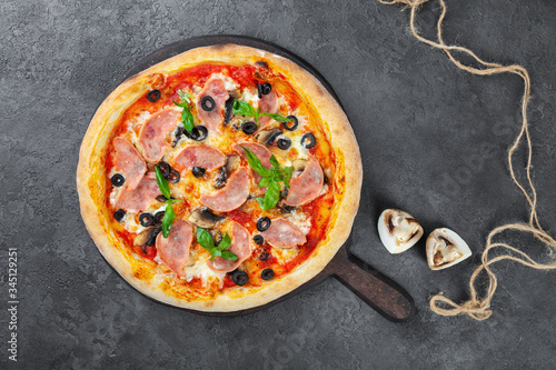 Meat pizza with carbonate, olives, mushrooms, tomatoes, basil, cheese