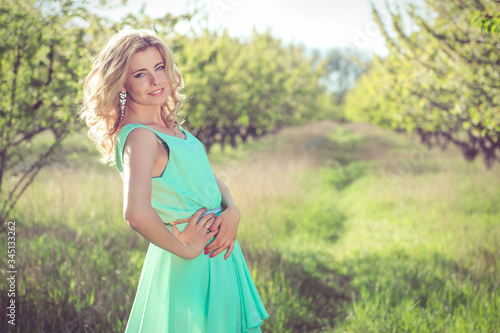 Fototapeta Naklejka Na Ścianę i Meble -  young blonde girl in a turquoise light dress