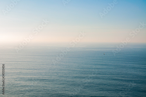 Vista da imensidão do mar com veleiro, no Cabo da Roca, Sintra, Portugal