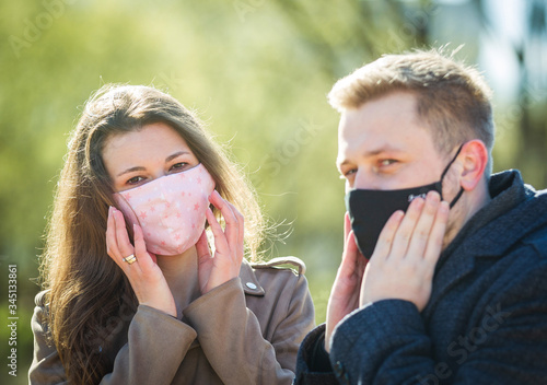 Masked young couple walking in the park photo