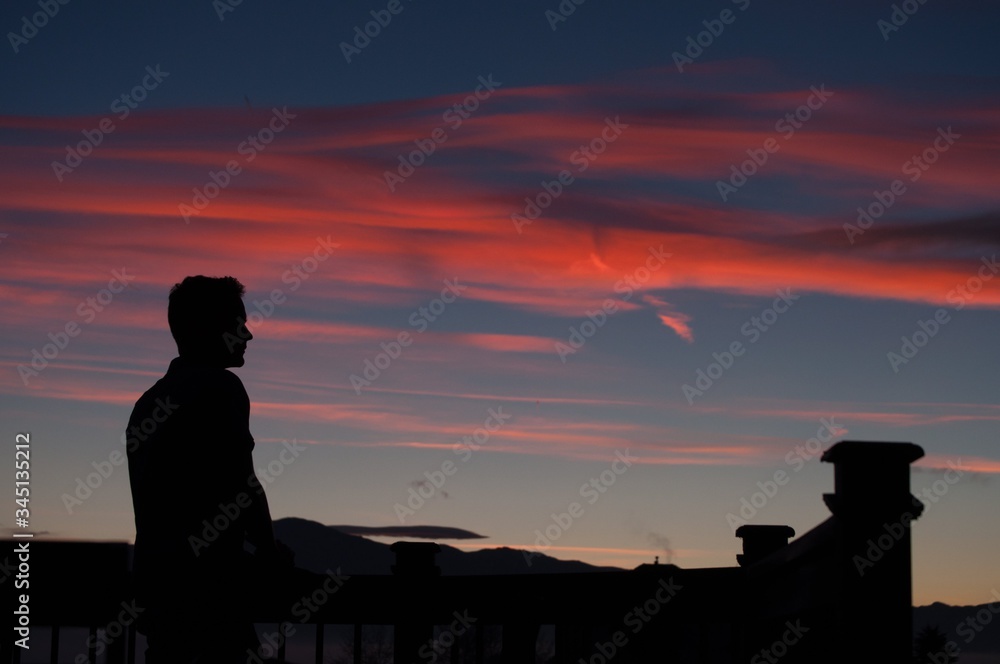 silhouette of man in front of sunset