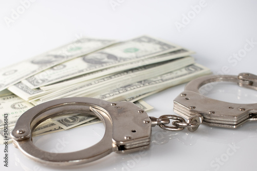 handcuffs sitting on top of US paper currency