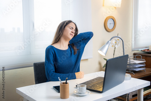 Teen student suffers neck pain with computer at home