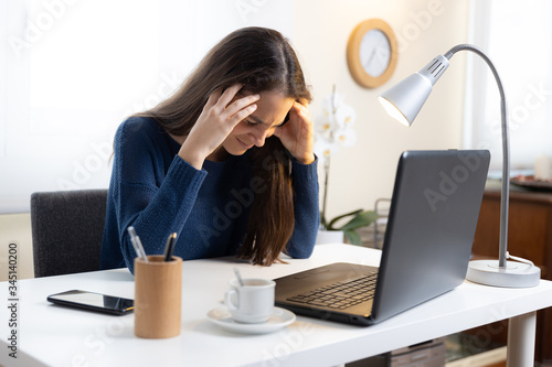Fotografie Teen student complains of headache with computer at home