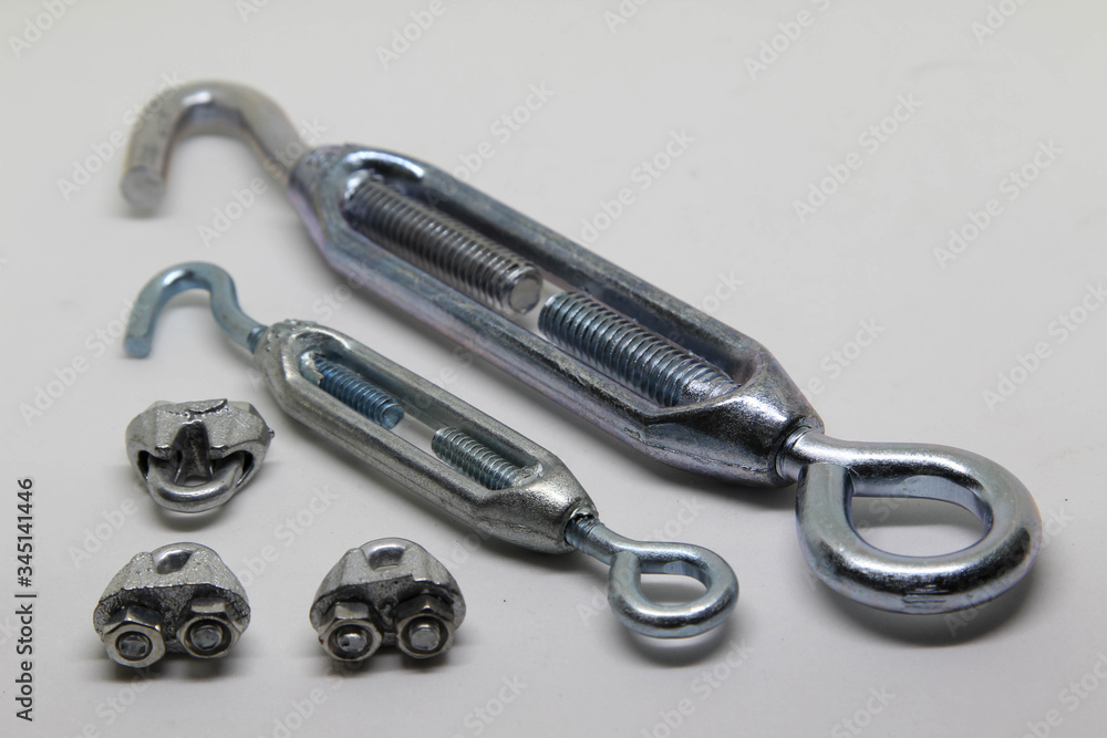 Steel turnbuckle and cable fasteners (wire rope clips) isolated on white background. Steel turnbuckle and cable fasteners (wire rope clips) isolated on white background.