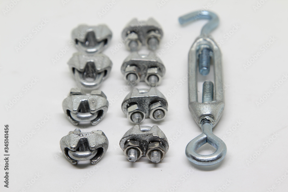 Steel turnbuckle and cable fasteners (wire rope clips) isolated on white background. Steel turnbuckle and cable fasteners (wire rope clips) isolated on white background.