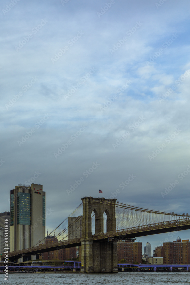 Vertical view evening shot of Brooklyn Bridge from Brooklyn Bridge Park in New York City with negative space for text. Vertical view evening shot of Brooklyn Bridge from Brooklyn Bridge Park in New York City with negative space for text.