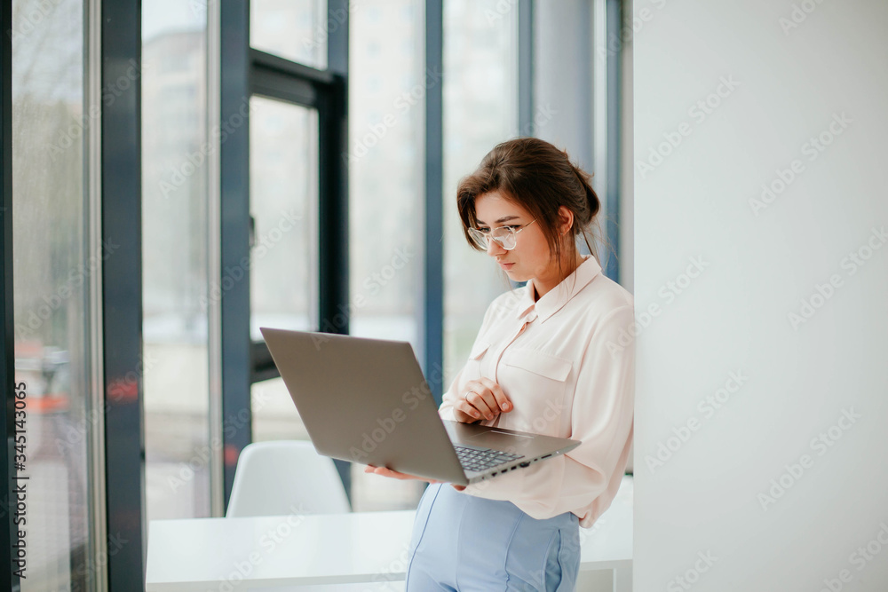 portrait of young businesswoman working on laptop in the office. portrait of young businesswoman working on laptop in the office.