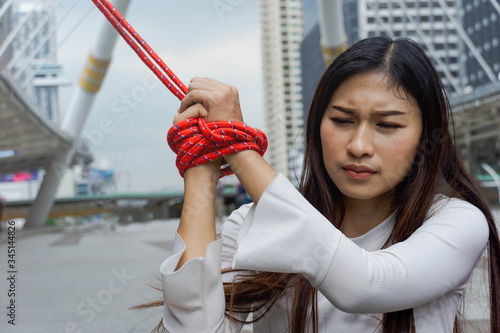 Female hands tied up with red rope. Woman hands bound prisoner. pain, afraid, restricted, trapped, kidnapped, abused, hostage, victim
