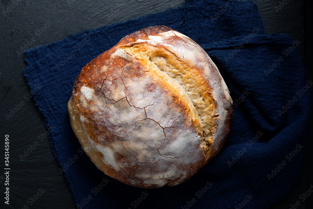 Dark mood and tone Home Cooking Homemade Organic rustic Sourdough bread on black background with copy space Dark mood and tone Home Cooking Homemade Organic rustic Sourdough bread on black background with copy space