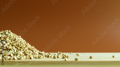 Green buckwheat seeds on a wooden background. Great food. healthy groats. Organic raw non-fried vegetarian food. The concept of a healthy, balanced and dietary diet. Copy space.