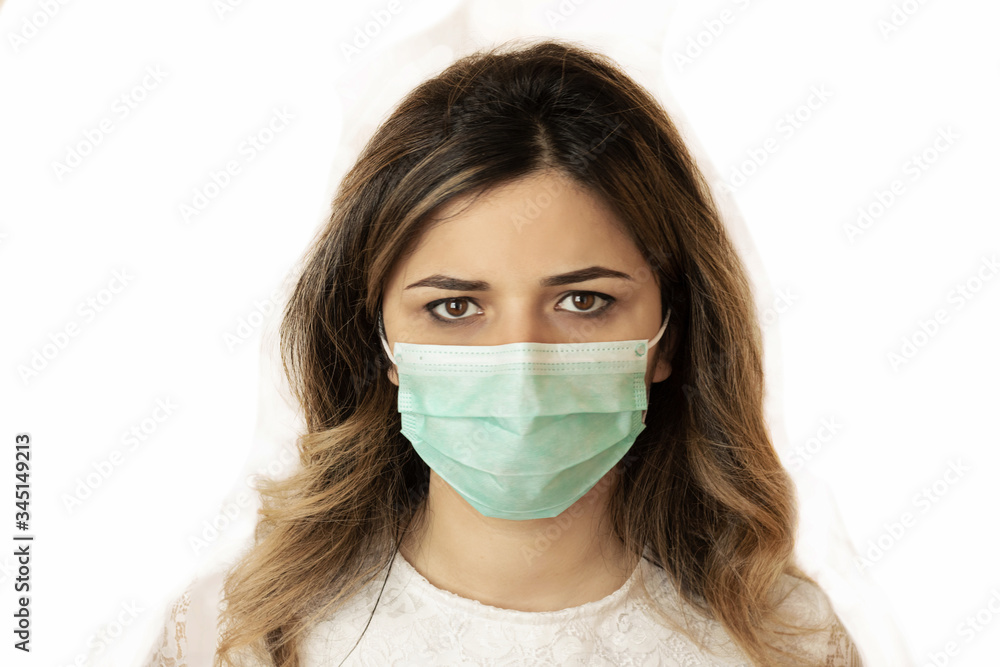Studio portrait of young woman wearing a face mask, looking at camera, close up, isolated on white background Studio portrait of young woman wearing a face mask, looking at camera, close up, isolated on white background