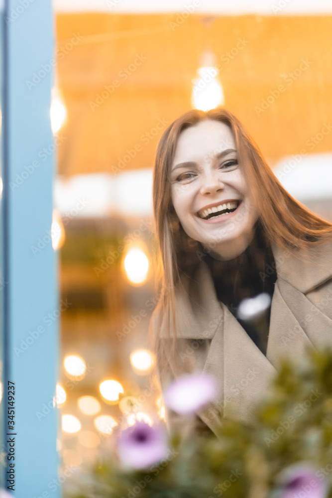 Outdoor fashion portrait of stylish young woman having fun, emotional face , laughing, Urban city street style wearing dark casual trousers, white sweater,creamy coat. and sunglasses Fashion concept.